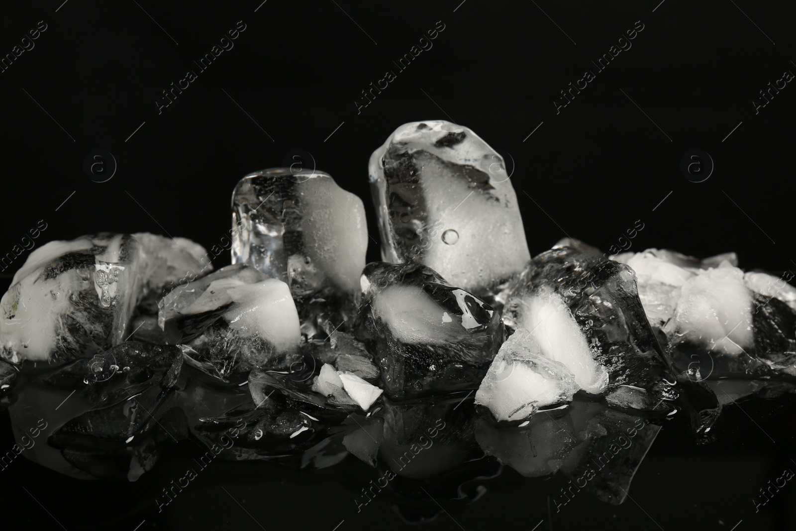 Photo of Pile of crushed ice on black mirror surface