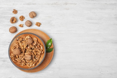Flat lay composition with tasty walnuts and space for text on wooden background