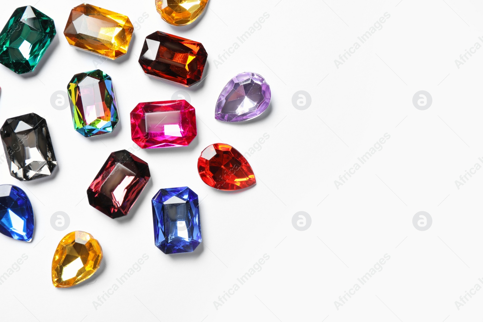 Photo of Different beautiful gemstones on white background, top view