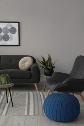 Stylish comfortable poufs and sofa in room. Home design