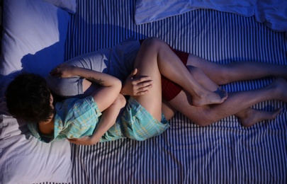 Photo of Young couple in love on bed at night time