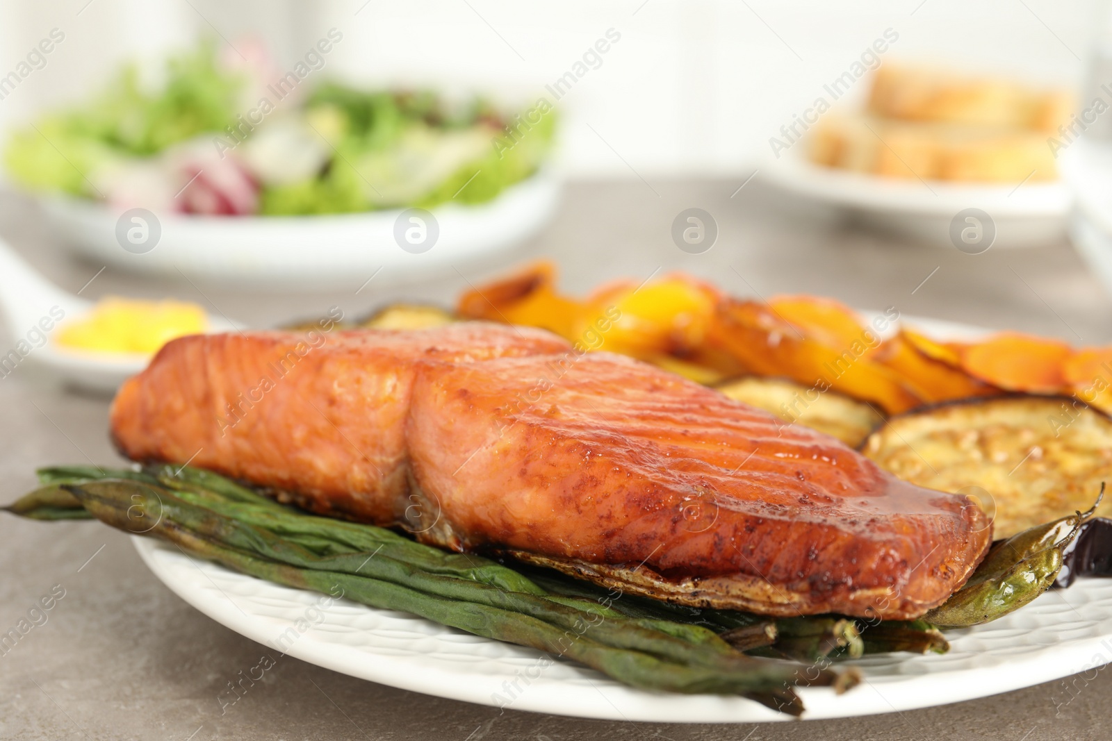 Photo of Delicious cooked salmon and vegetables on grey table, closeup. Healthy meals from air fryer