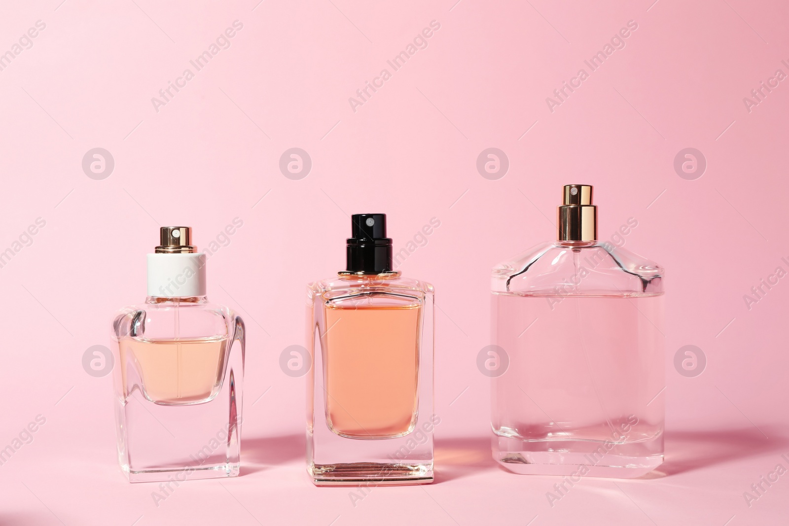 Photo of Bottles of perfume on color background