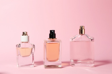 Bottles of perfume on color background