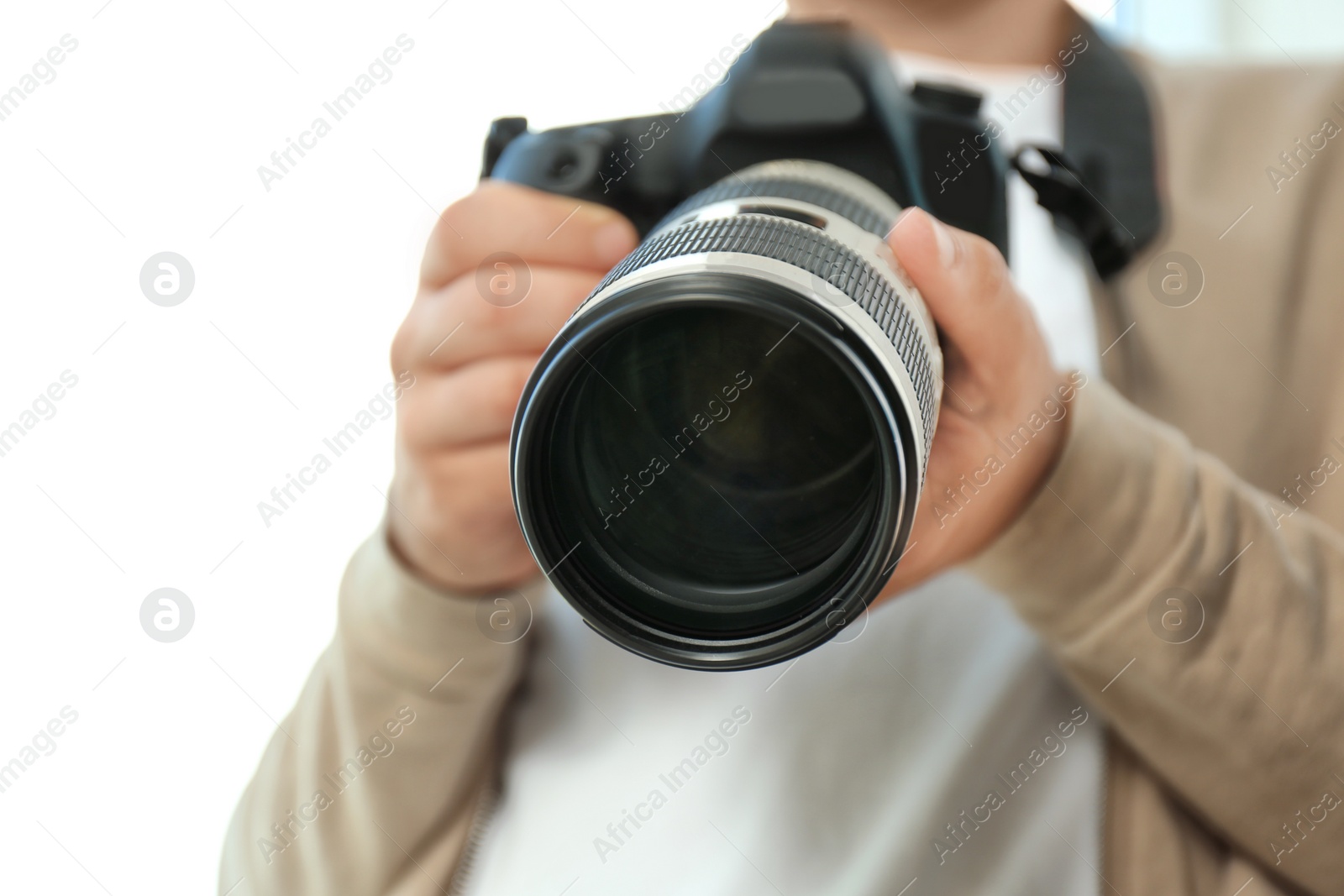 Photo of Male photographer with professional camera on white background, closeup