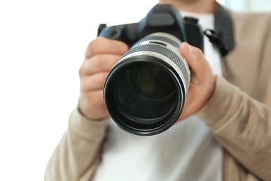 Male photographer with professional camera on white background, closeup