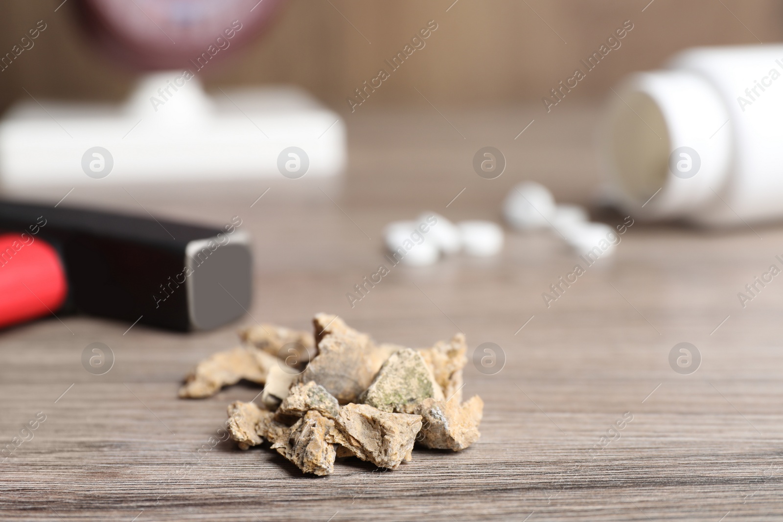 Photo of Pile of kidney stones on wooden table, closeup. Space for text