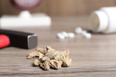 Photo of Pile of kidney stones on wooden table, closeup. Space for text
