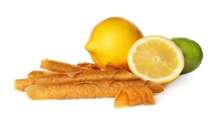 Delicious fruit leather rolls, lime and lemons on white background