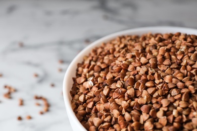 Photo of Uncooked organic buckwheat grains in bowl, closeup