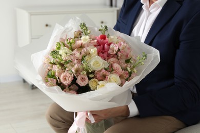 Photo of Man with beautiful bouquet of flowers indoors, closeup