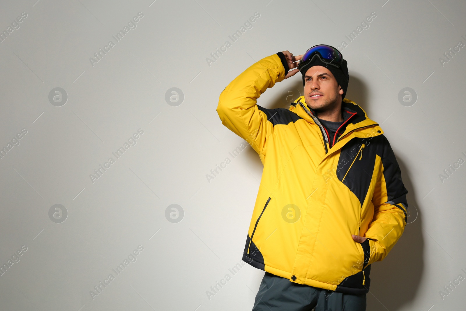 Photo of Man wearing stylish winter sport clothes on light grey background