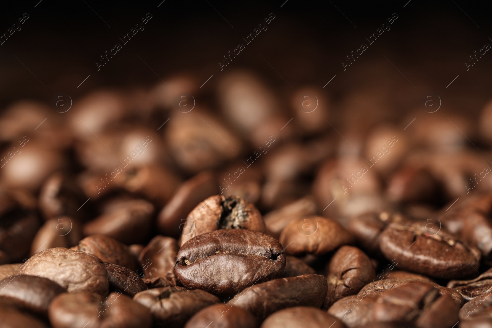 Photo of Heap of aromatic roasted coffee beans, closeup