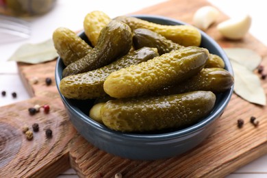 Photo of Tasty pickled cucumbers and spices on wooden board, closeup