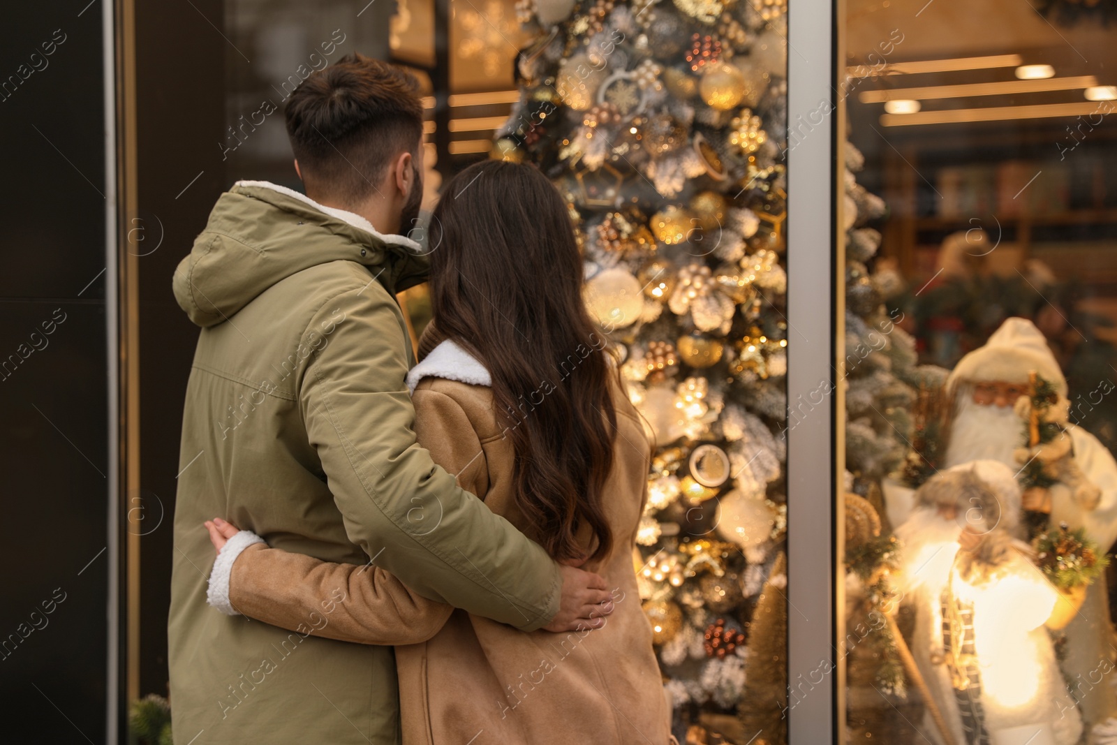 Photo of Lovely couple near store decorated for Christmas outdoors, back view
