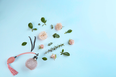 Photo of Beautiful composition with bottle of perfume and flowers on white background, flat lay. Space for text