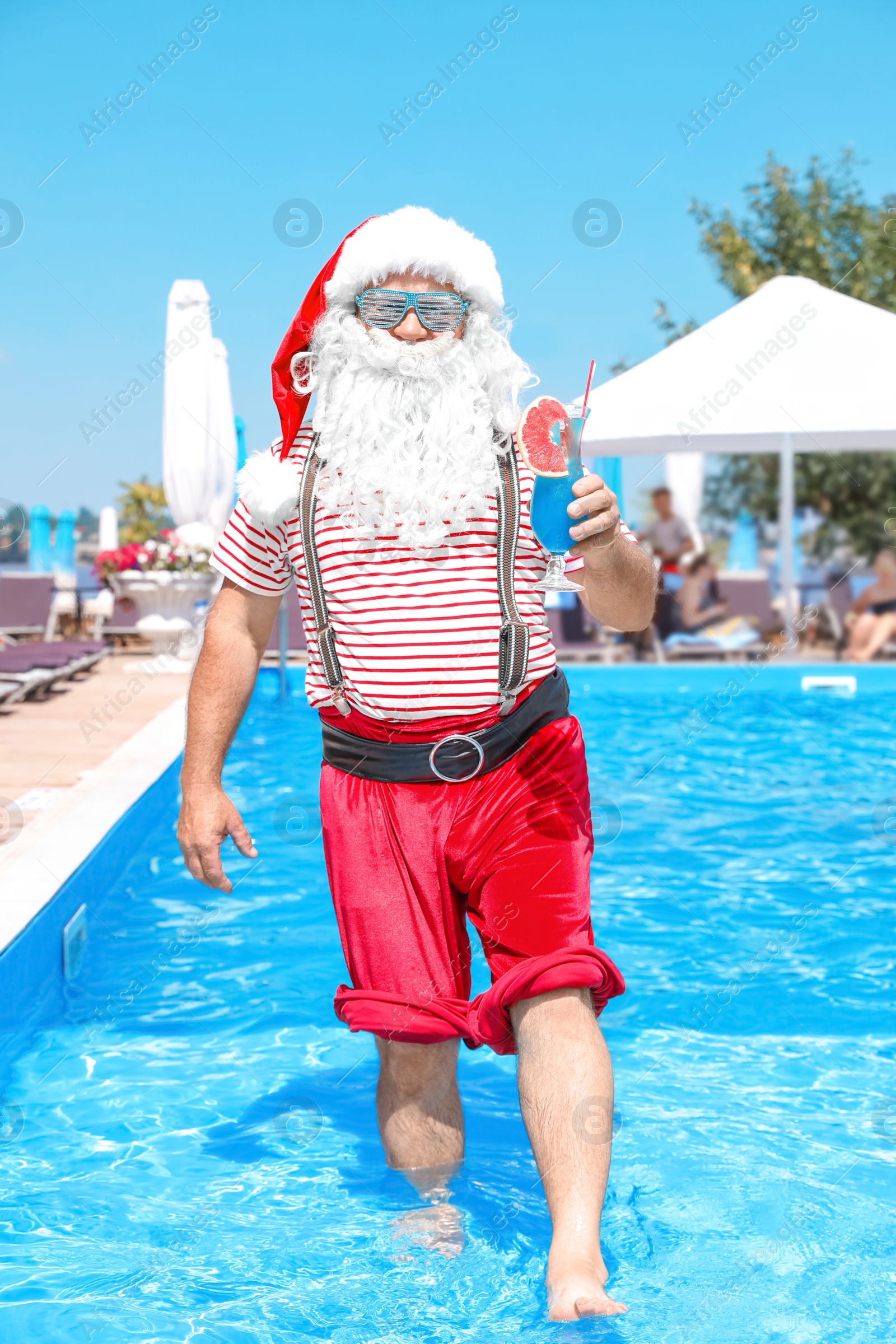 Photo of Authentic Santa Claus with cocktail in pool at resort