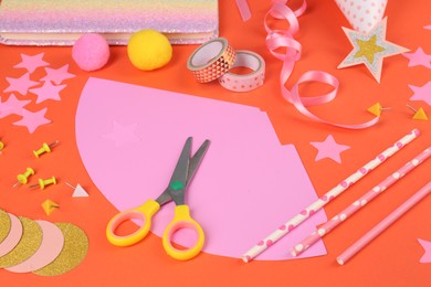 Photo of Different stationery and materials for creation of colorful party hats on orange background. Handmade decorations