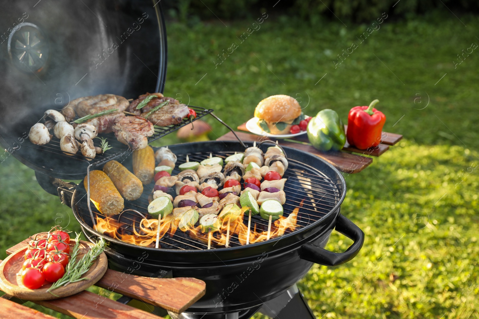 Photo of Cooking meat and vegetables on barbecue grill outdoors