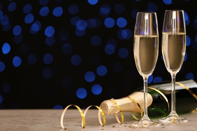 Photo of New year composition with champagne and space for text against blurred Christmas lights