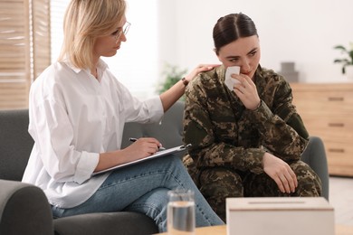 Photo of Psychotherapist working with military woman on sofa in office