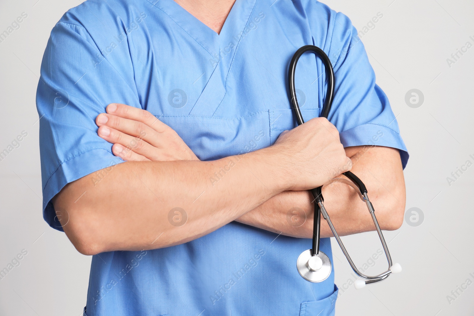 Photo of Medical assistant with stethoscope on color background, closeup