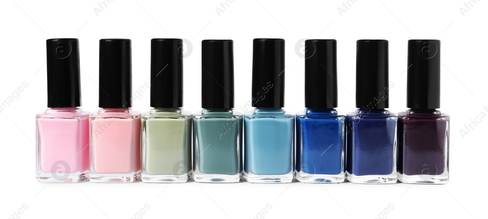 Photo of Beautiful nail polishes in bottles isolated on white