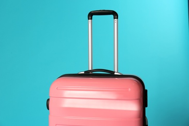 Photo of Stylish carry on suitcase on color background