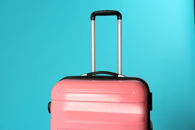 Stylish carry on suitcase on color background