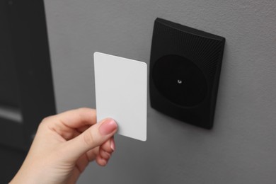 Photo of Woman opening magnetic door lock with key card, closeup. Home security