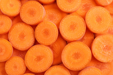 Photo of Slices of fresh ripe carrot as background, top view