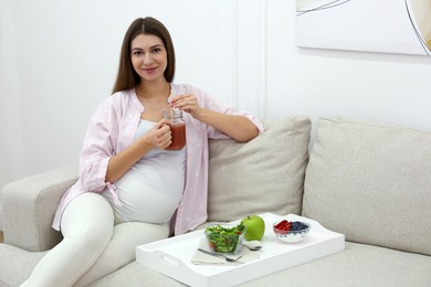 Pregnant woman eating breakfast at home. Healthy diet