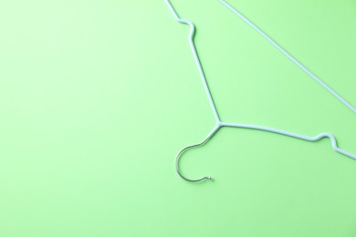 Photo of One blue hanger on light green background, top view. Space for text