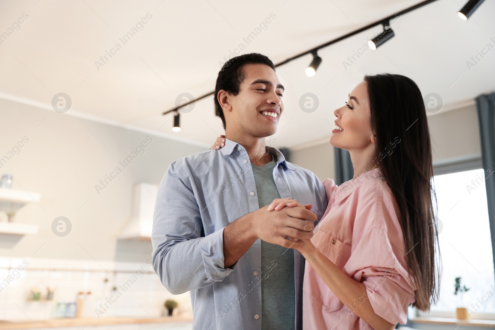 Photo of Lovely young interracial couple dancing at home