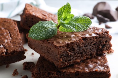 Delicious chocolate brownies with fresh mint on marble board, closeup