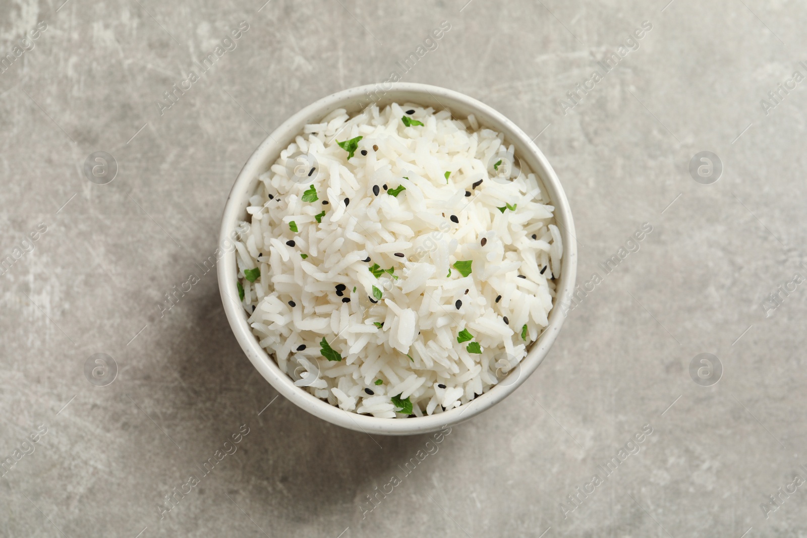 Photo of Bowl of tasty cooked rice on grey background, top view