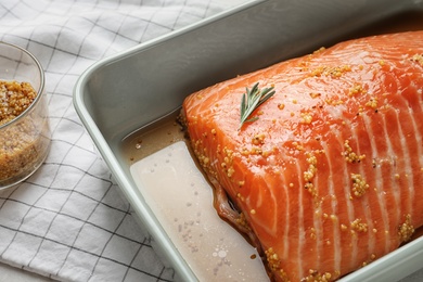 Marinated salmon fillet in dish on table, closeup