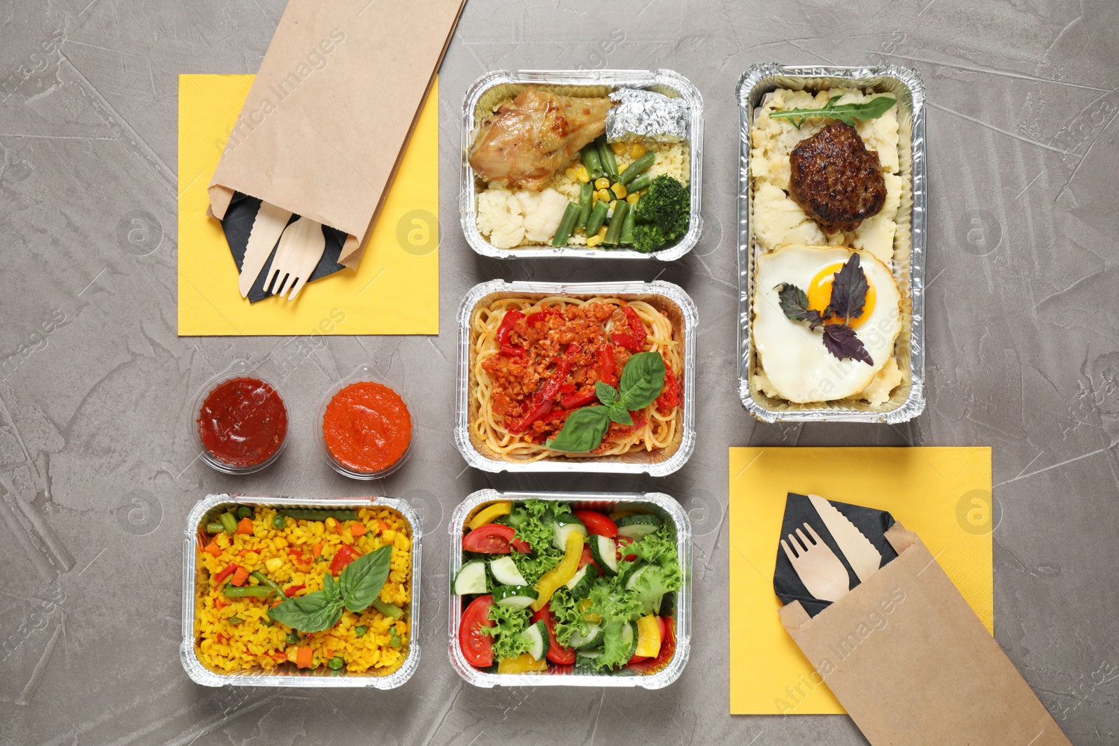 Photo of Lunchboxes on grey table, flat lay. Healthy food delivery