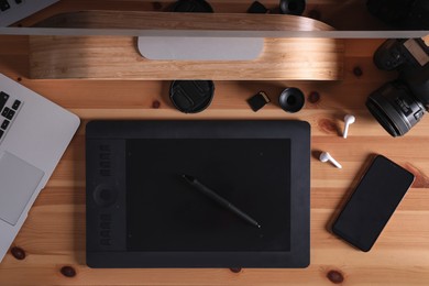 Photo of Modern retoucher's workplace with digital devices on wooden table, flat lay