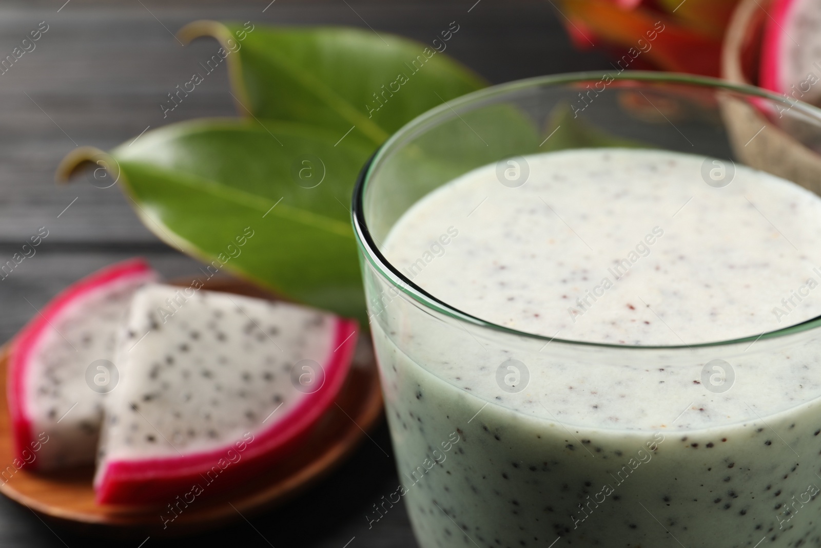 Photo of Delicious pitahaya smoothie and fresh fruits on table, closeup. Space for text