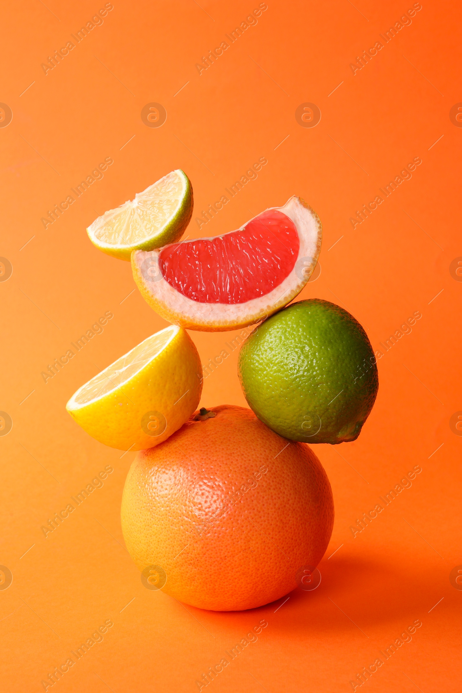 Photo of Fresh ripe citrus fruits on orange background