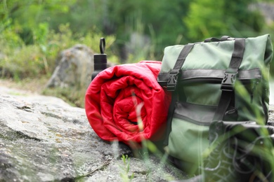Rolled sleeping bag and other camping gear outdoors