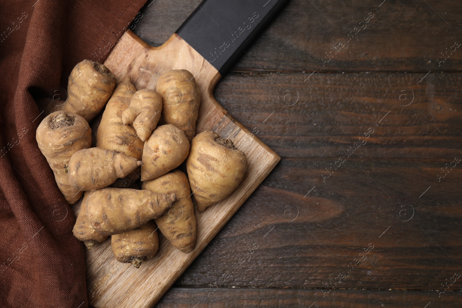 Photo of Tubers of turnip rooted chervil on wooden table, top view. Space for text