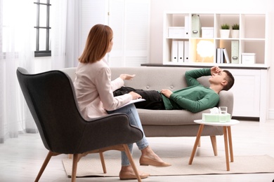 Photo of Psychotherapist working with young man in office