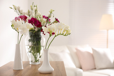 Photo of Beautiful spring freesia flowers in light room, space for text