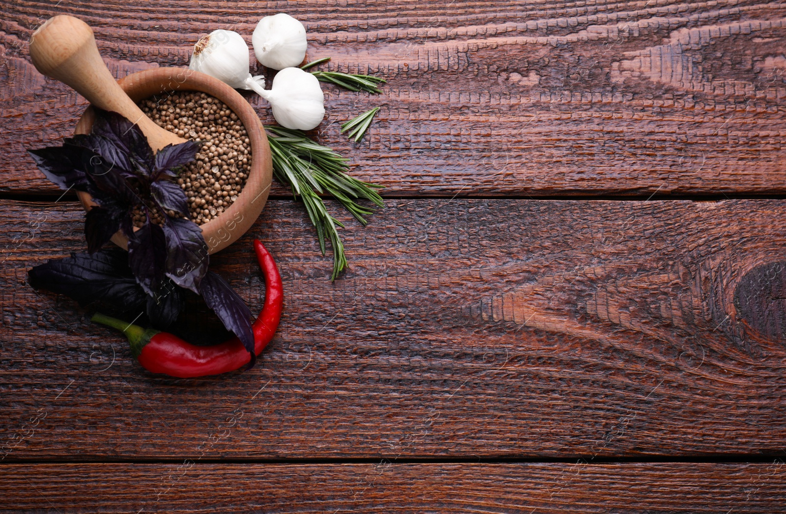 Photo of Flat lay composition with mortar and different spices on wooden table, space for text