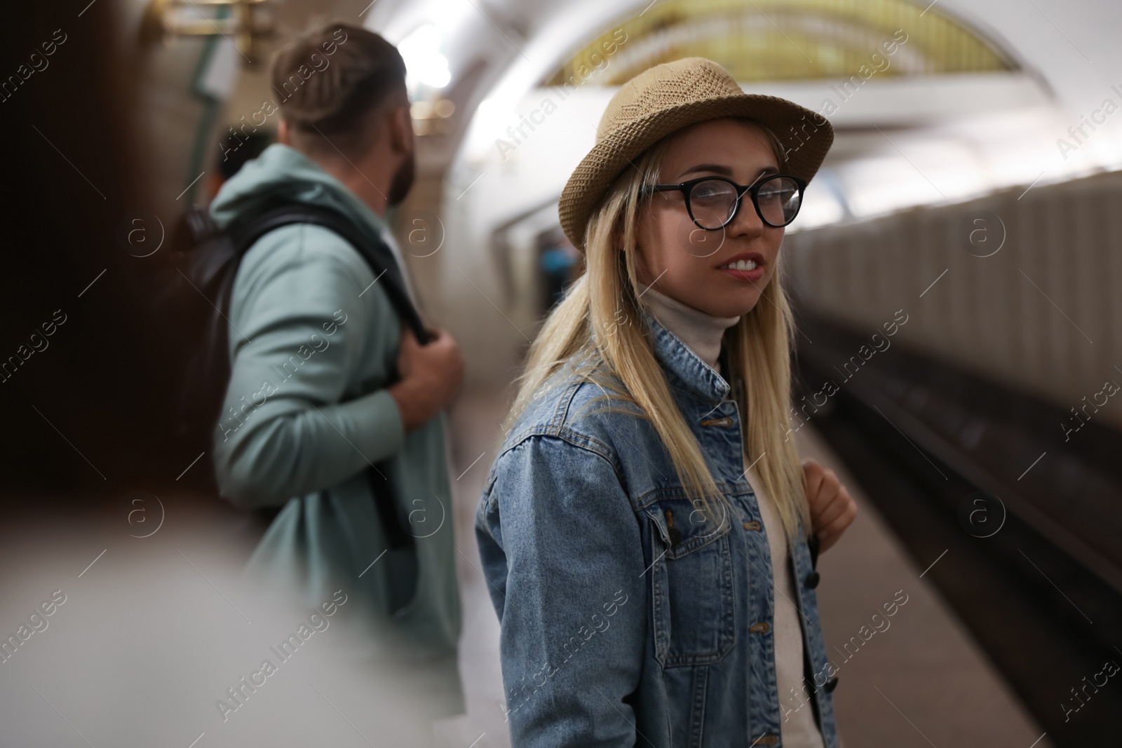 Photo of Young woman at subway station, space for text. Public transport