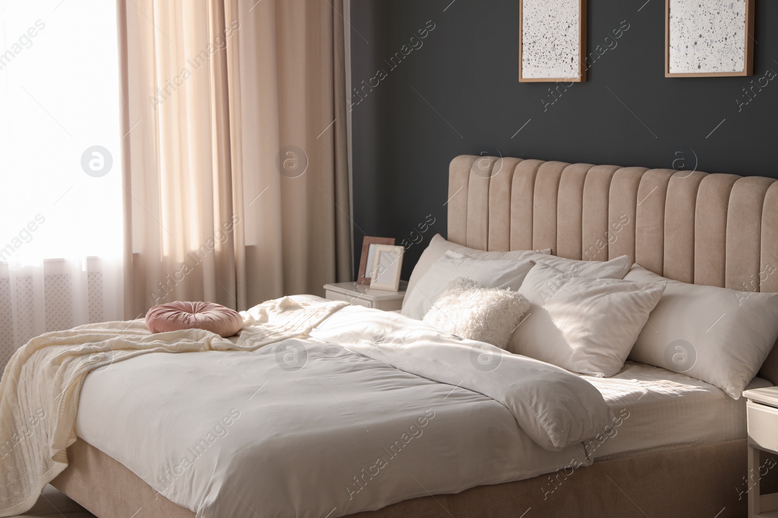 Photo of Comfortable bed with soft blanket near window indoors
