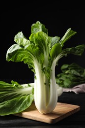 Photo of Fresh green pak choy cabbages on black wooden table