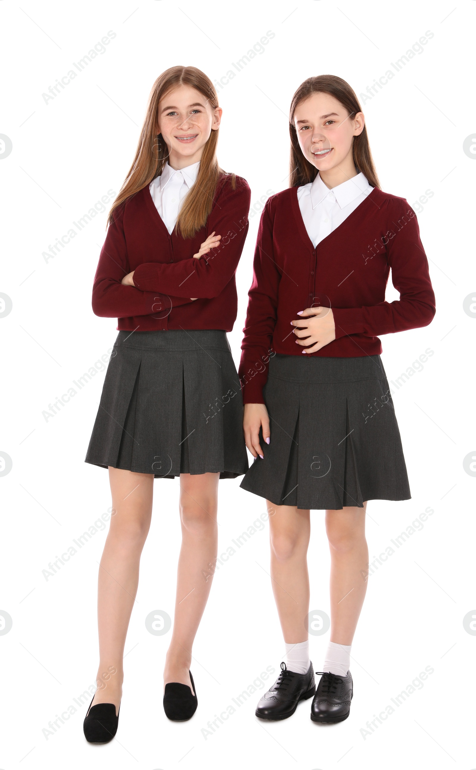 Photo of Full length portrait of teenage girls in school uniform on white background
